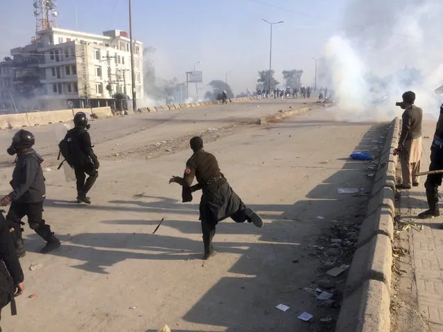 Pakistani police officers fire tear gas shell to disperse protesters during a clash in Islamabad, Pakistan, Saturday, November 25, 2017. Pakistani police have launched an operation to clear an intersection linking capital Islamabad with the garrison city of Rawalpindi where an Islamist group's supporters have camped out for the last 20 days. (Photo by Anjum Naveed/AP Photo)