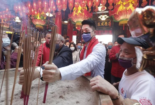 Taipei city Mayor Wayne Chiang, center, prays at a temple on the first day of the Lunar New Year celebrations in Taipei, Taiwan, Sunday, January 22, 2023. Each year is named after one of the 12 signs of the Chinese zodiac in a repeating cycle, with this year being the Year of the Rabbit. (Photo by Chiang Ying-ying/AP Photo)