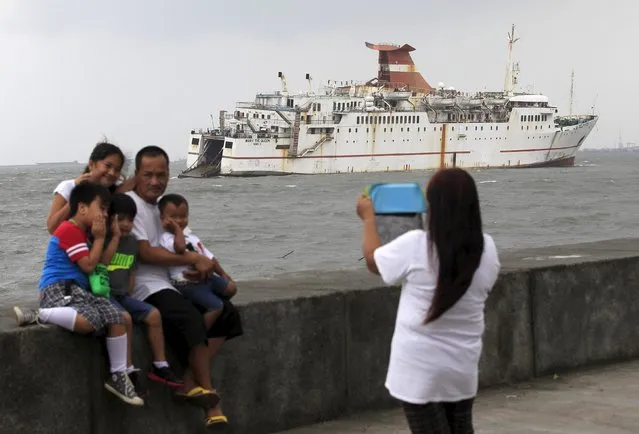 A family takes photos in front of a ferry boat that ran aground due to strong waves brought by Typhoon Koppu near the breakwater of Manila bay on October 19, 2015. Typhoon Koppu swept across the northern Philippines killing at least nine people as trees, power lines and walls were toppled and flood waters spread far from riverbeds, but tens of thousands of people were evacuated in time. (Photo by Romeo Ranoco/Reuters)