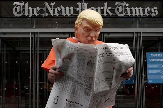 Mike Hisey dressed as U.S. President Donald Trump in a prison jumpsuit reads the New York Times in front of the New York Times office in the Manhattan borough of New York City, New York, U.S., September 28, 2020. (Photo by Carlo Allegri/Reuters)