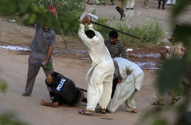 Anti-government protesters beat a riot policeman after clashes during the Revolution March in Islamabad, in this September 1, 2014 file photo. (Photo by Faisal Mahmood/Reuters)