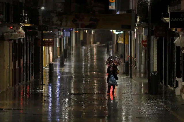 A worker walks along an empty street during the first day of the nighttime curfew set as part of a state of emergency in an effort to control the outbreak of the coronavirus disease (COVID-19), in downtown Ronda, southern Spain, late October 25, 2020. (Photo by Jon Nazca/Reuters)