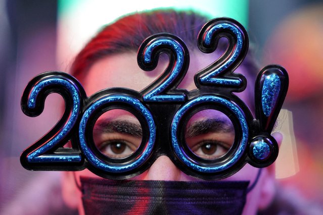 A person looks on as revelers gather during New Year's Eve celebrations in Times Square as the Omicron coronavirus variant continues to spread in the Manhattan borough of New York City, U.S., December 31, 2021. (Photo by Dieu-Nalio Chery/Reuters)