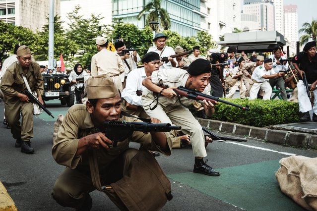 Actors perform a reenactment of the 1949 General Offensive on Surakarta, one of the last major battles after Indonesia's 1945 independence proclamation against Dutch forces that refused to recognize it, during National Veterans Day commemorations on a street in Jakarta on August 10, 2025. (Photo by Yasuyoshi Chiba/AFP Photo)