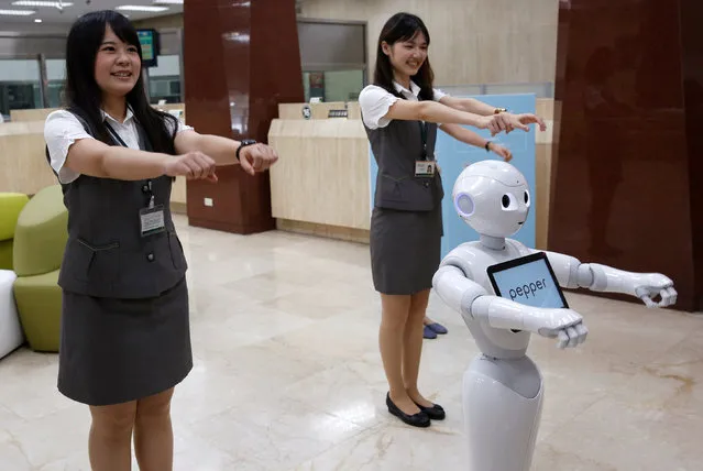 SoftBank's robot “Pepper” performs with employees at First Bank branch in Taipei, Taiwan October 6, 2016. (Photo by Tyrone Siu/Reuters)