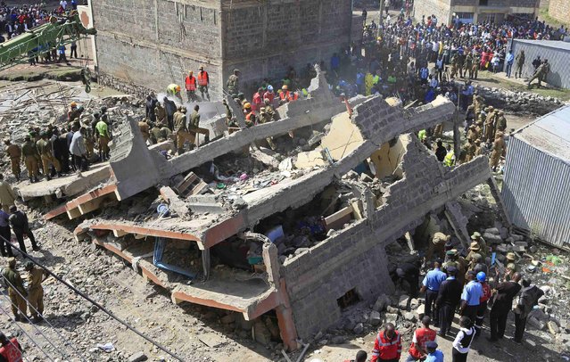 Rescuers search for survivors in the rubble of a collapsed residential building in Makongeni estate in Kenya's capital Nairobi December 17, 2014. Three more bodies were recovered on Wednesday night from the building that collapsed in Makongeni estate in Nairobi, raising the death toll to four, Kenya Red Cross has reported. (Photo by Noor Khamis/Reuters)