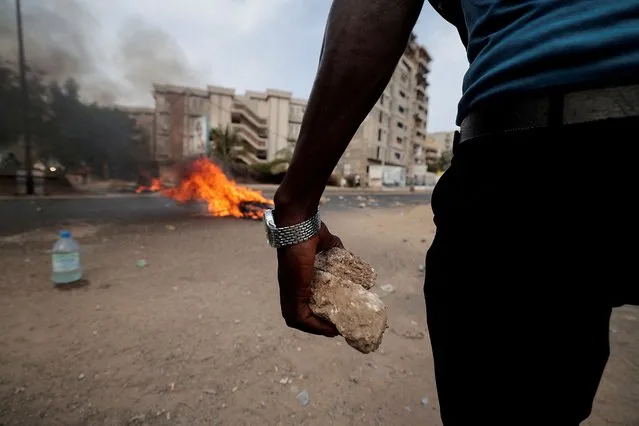 A supporter of Senegal opposition leader Ousmane Sonko holds a stone during clashes with security forces ahead of his leader's court appearance for a libel case against him in Dakar, Senegal on March 16, 2023. (Photo by Zohra Bensemra/Reuters)