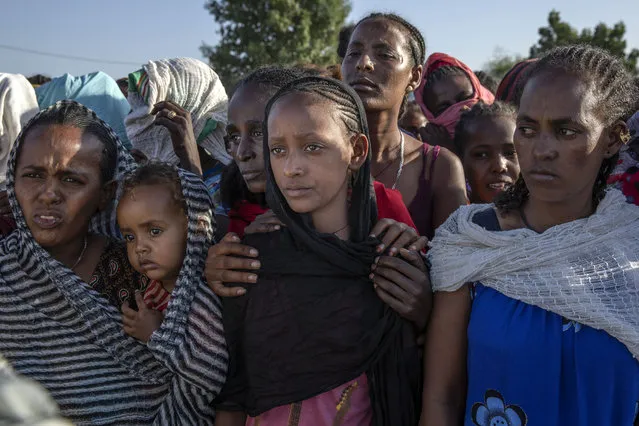 Tigray women who fled a conflict in the Ethiopia's Tigray region, wait to receive aid at Village 8, the transit centre near the Lugdi border crossing, eastern Sudan, Sunday, November 22, 2020. Ethiopia's military is warning civilians in the besieged Tigray regional capital that there will be “no mercy” if they don't “save themselves” before a final offensive to flush out defiant regional leaders, a threat that Human Rights Watch on Sunday said could violate international law. (Photo by Nariman El-Mofty/AP Photo)