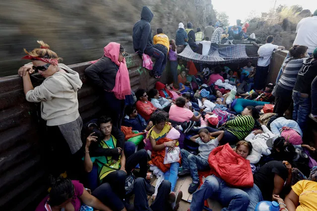 Central American migrants, moving in a caravan through Mexico, travel in an open wagon of a freight train after stopping it on the rail line, in Hidalgo state, Mexico April 14, 2018. (Photo by Edgard Garrido/Reuters)