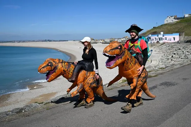 Oscar Dethick and Georgie Deane are seen at Chesil Beach dressed as dinosaurs for their DinoDash, as they walk the Jurassic coast in aid of The Dorset Children's Foundation, on April 04, 2023 in Portland, England. (Photo by Finnbarr Webster/Getty Images)