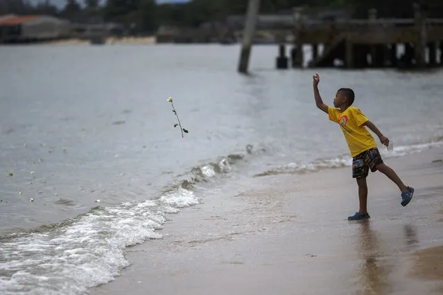 A boy throws a rose into the sea near a monument for victims of the 2004 tsunami in Ban Nam Khem, a southern fishing village destroyed by the tsunami, December 26, 2014. Survivors of Asia's 2004 tsunami and relatives of its 226,000 victims cried and prayed as they gathered along Indian Ocean shorelines on Friday for memorials to mark the 10th anniversary of a disaster that still leaves an indelible mark on the region. (Photo by Athit Perawongmetha/Reuters)