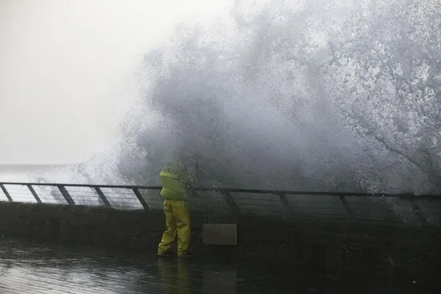 A man tries to take pictures of the Mediterranean Sea as waves break on Tel Aviv's beach promenade January 6, 2015. (Photo by Baz Ratner/Reuters)