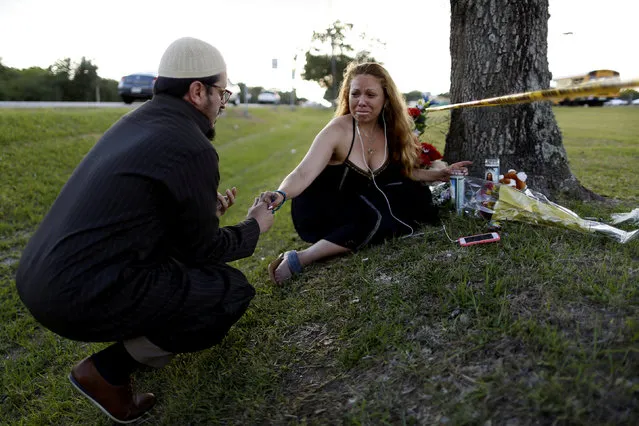 Daniel Hernandez, a local imam, comforts Dih-Anaa Forero of Missouri City, near the site of the shooting at the Santa Fe High School, in Santa Fe, Texas, U.S., May 19, 2018. (Photo by Jonathan Bachman/Reuters)