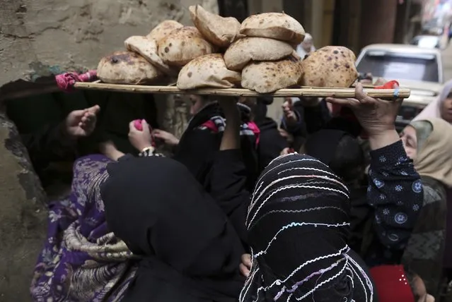 Women purchase bread through a window at a bakery in Cairo, January 8, 2015. (Photo by Mohamed Abd El Ghany/Reuters)
