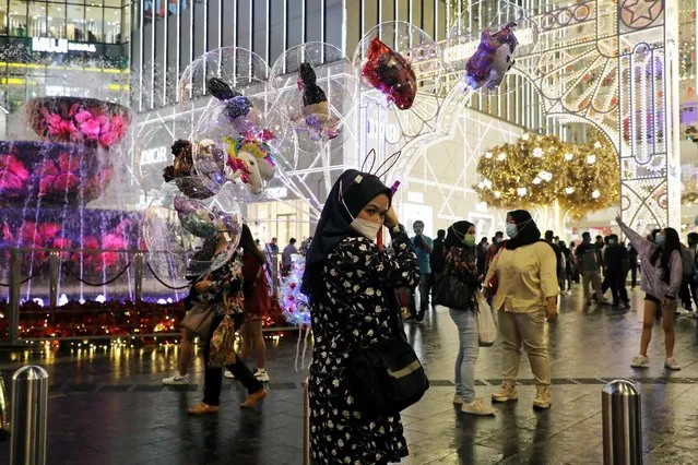 A vendor wearing a protective mask sells balloons outside a shopping mall during New Year's Eve, amid the coronavirus disease (COVID-19) outbreak in Kuala Lumpur, Malaysia on December 31, 2020. (Photo by Lim Huey Teng/Reuters)
