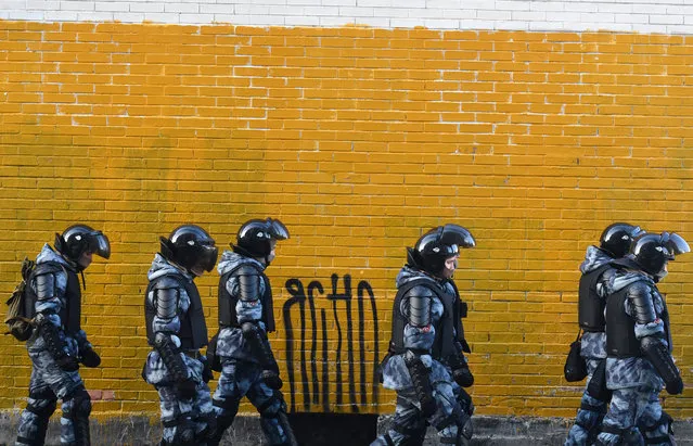 Law enforcement officers walk past a wall near the Moscow City Court during the trial of Russian opposition leader Alexei Navalny, charged with violating the terms of a 2014 suspended sentence for embezzlement, in Moscow on February 2, 2021. (Photo by Natalia Kolesnikova/AFP Photo)