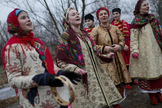 Ukrainians dressed in traditional costumes sing during Orthodox Epiphany celebrations in Kiev January 19, 2015. (Photo by Gleb Garanich/Reuters)