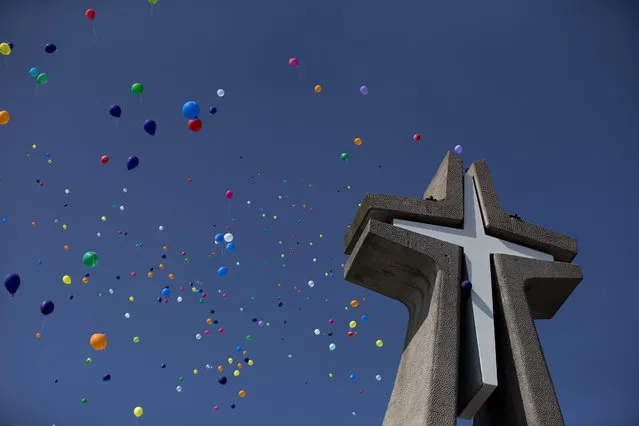 Balloons released by clowns rise over the cross at the Basilica of Our Lady of Guadalupe in Mexico City, Monday, December 14, 2015. (Photo by Rebecca Blackwell/AP Photo)