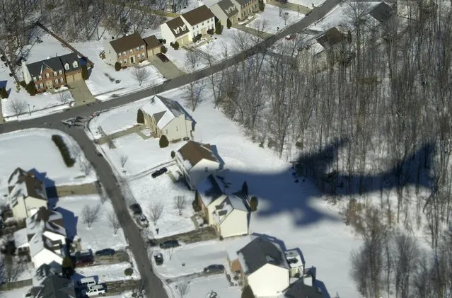 Air Force One casts its shadow over snow-covered houses in Waldorf, Maryland, in this January 31, 2004 file photo. (Photo by Jason Reed/Reuters)