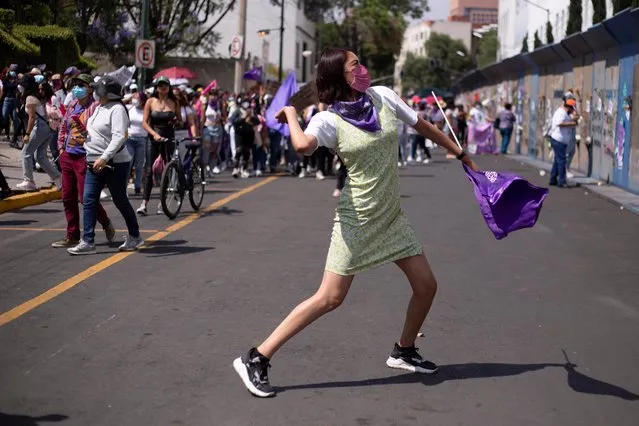 A woman throws a stone in a march to demand justice for the victims of gender violence and femicides after the death of Debanhi Escobar, an 18-year-old law student whose body was found submerged in a water tank inside the grounds of a motel in the northern state of Nuevo Leon, in Mexico City, Mexico on April 24, 2022. (Photo by Quetzalli Nicte-Ha/Reuters)