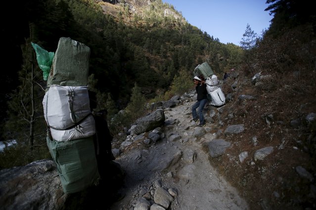 Porters take a break from carrying goods as they head towards Namche in Solukhumbu district, also known as the Everest region, in this picture taken November 29, 2015. (Photo by Navesh Chitrakar/Reuters)