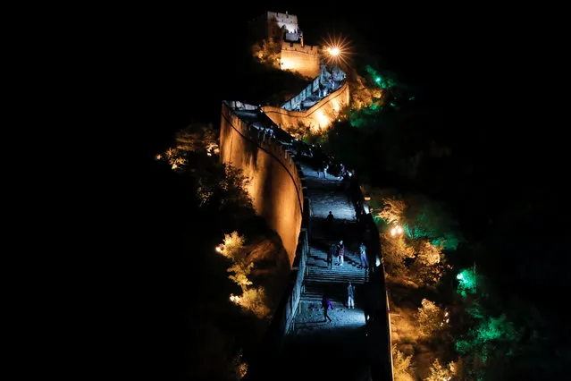 People climb the Great Wall that is illuminated to mark the first day of Mid-Autumn Festival and the Chinese National Day, in Beijing, China, October 1, 2020. (Photo by Thomas Peter/Reuters)
