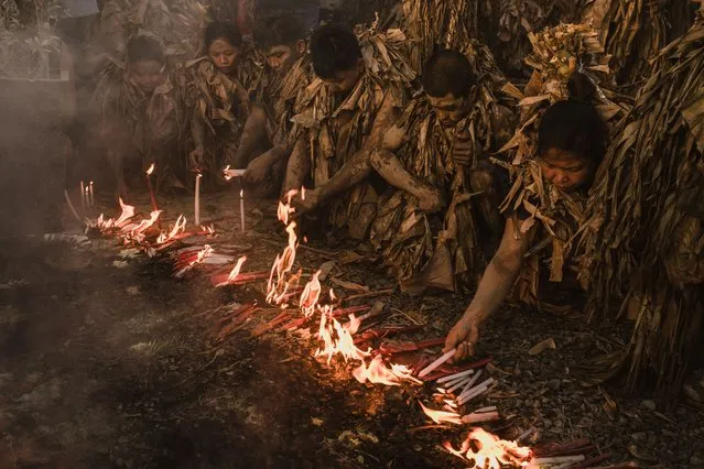 Devotees in a small farming village in Bibiclat celebrate the feast of Saint John the Baptist while covered in banana leaves and mud on June 24, 2023 in Aliaga, north of Manila, Philippines. Known as the “Taong Putik” (mud people), the ritual happens yearly in this small farming village as their own version of expressing their faith and celebrating the feast of Saint John the Baptist whom the survivors of the Japanese occupation in 1944 in their area prayed to for rain to save their fellow villagers. A marker near the church entrance of the village tells a story of a heavy torrential rain that happened that day that forced the Japanese military to call off the execution of 14 villagers. The Philippines is the only predominantly Catholic country in Southeast Asia after more than 300 years of Spanish rule. (Photo by Jes Aznar/Getty Images)
