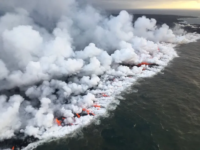 This image obtained June 26, 2018 from the US Geological Survey shows the lava entering the sea and releasing multiple laze plumes at Kilauea Volcano, Hawaii. (Photo by AFP Photo/US Geological Survey)