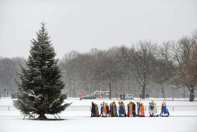 Carol singers from the Paderborn Archdiocese walk through the snow covered grounds of Schloss Bellevue in Berlin, Germany, 06 January 2016. (Photo by Gregor Fischer/EPA)