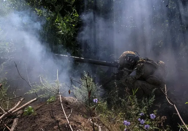 A Ukrainian serviceman, of the 10th separate mountain assault brigade of the Armed Forces of Ukraine, fires an anti-tank grenade launcher at his position at a front line, amid Russia's attack on Ukraine, near the city of Bakhmut in Donetsk region, Ukraine on July 13, 2023. (Photo by Sofiia Gatilova/Reuters)
