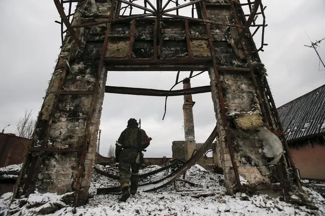 A member of the armed forces of the separatist self-proclaimed Donetsk People's Republic walks near a building destroyed during battles with the Ukrainian armed forces in Vuhlehirsk, Donetsk region, Ukraine, in this February 4, 2015 file photo. (Photo by Maxim Shemetov/Reuters)