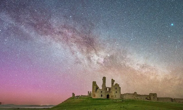 A brilliant image shows the Milky Way rising behind Dunstanburgh Castle in Northumberland, United Kingdom during the late hours on April 18, 2023, combined with the slight glow of the northern lights. (Photo by Lewis Brown/Story Picture Agency)