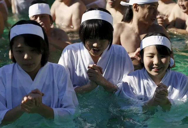 Women wearing "Shiroshozoku" or the traditional white robe pray as they bathe in ice-cold water at the Teppozu Inari shrine in Tokyo, Japan, January 10, 2016. (Photo by Yuya Shino/Reuters)