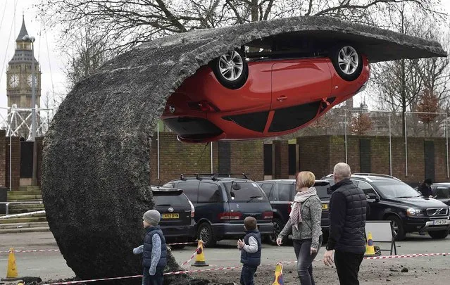 Pedestrians pass an upside down car art installation in a car park on the South Bank in London, February 19, 2015. (Photo by Toby Melville/Reuters)