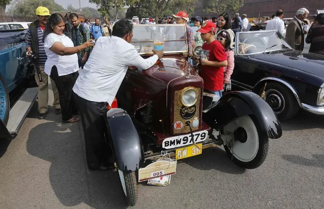 A participant fills petrol in his 1923 Rover car before the start of a vintage car rally in front of the historic Red Fort in the old quarters of Delhi February 21, 2015. (Photo by Adnan Abidi/Reuters)