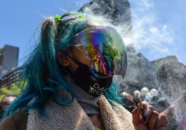 An activist smokes marijuana during the annual NYC Cannabis Parade & Rally in support of the legalization of marijuana for recreational and medical use, on May 1, 2021 in New York City. New York Governor Andrew Cuomo signed legislation legalizing recreational marijuana on March 31, 2021, with a large chunk of tax revenues from sales set to go to minority communities. (Photo by Angela Weiss/AFP Photo)