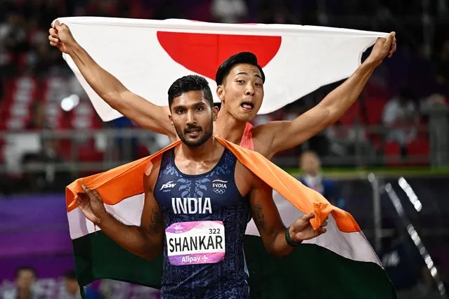 Japan's Yuma Maruyama (R) and India's Tejaswin Shankar celebrate after the men's decathlon 1,500m athletics event during the 2022 Asian Games in Hangzhou in China's eastern Zhejiang province on October 3, 2023. (Photo by Dylan Martinez/Reuters)