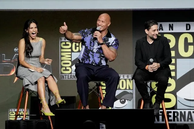 Actor Dwayne Johnson gestures onstage as moderator Tiffany Smith and director Jaume Collet-Serra react during a panel promoting the DC Comics superhero film Black Adam, at Comic-Con International in San Diego, California, U.S., July 23, 2022. (Photo by Bing Guan/Reuters)