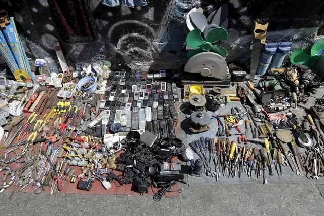 Used tools, cell phones, remote controls and other used items for sale are pictured at an improvised store at a main street in Caracas, January 25, 2016. (Photo by Marco Bello/Reuters)