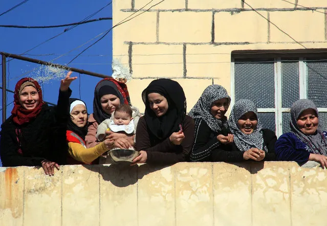 Syrians celebrate after pro-government forces broke an opposition siege in the northern Shiite town of Nubol, on February 4, 2016, during a regime operation aimed at severing the main rebel supply route into Aleppo. The advance – which has seen the most significant government victories since staunch ally Russia launched air strikes last year – brings government forces closer than ever to encircling rebels who have held the east of Aleppo city since mid-2012. (Photo by George Ourfalian/AFP Photo)
