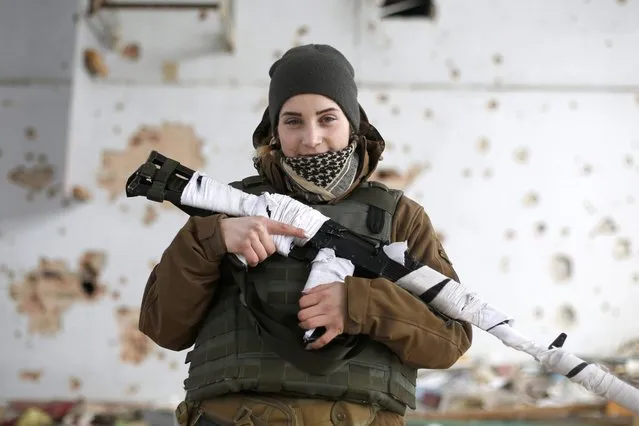 Olena, a 22-year-old fighter photographed in Marinka, Ukraine on January 18, 2018. She began fighting as a volunteer aged just 17. When not on the front lines, she is studying theater directing at the Kyiv University of Culture and Arts. More than one-quarter of Ukraine's combatants are younger than 30, a shift from the early days of the conflict in which older, sometimes pension-age volunteers bore more of the weight of the conflict for Ukraine. (Photo by Anatoliy Stepanov/Radio Free Europe/Radio Liberty)