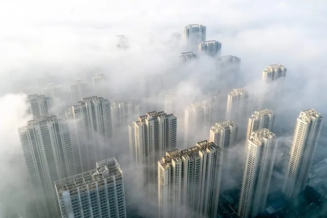This aerial photo taken on November 27, 2023 shows fog over residential buildings in Wuhan, in China's central Hubei province. (Photo by AFP Photo/China Stringer Network)