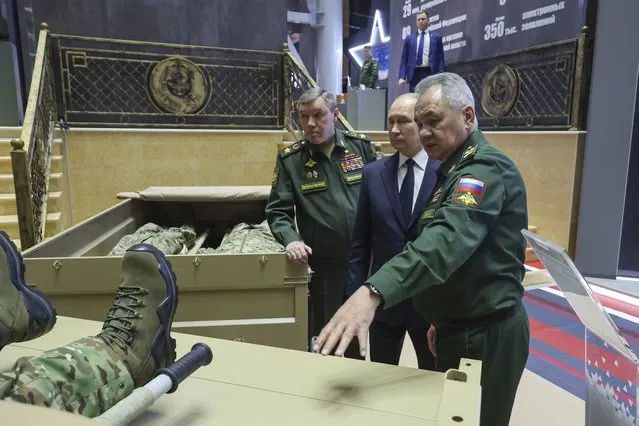 Russian President Vladimir Putin, center, Russian Chief of General Staff Gen. Valery Gerasimov, left, and Russian Defense Minister Sergei Shoigu look at examples of Russian Army uniform after a meeting with the top military brass in Moscow, Russia, Tuesday, December 19, 2023. (Photo by Mikhail Klimentyev, Sputnik, Kremlin Pool Photo via AP Photo)