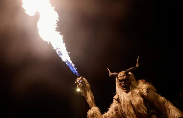 A person dressed as a horned evil spirit known as “Krampus” parades with a torch through the small town of Goricane, Slovenia on November 18, 2023. (Photo by Borut Zivulovic/Reuters)