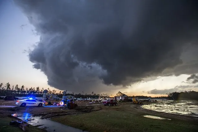 Storm clouds approach emergency crews at the scene of a house cut in half by a tornado near where seven people were killed outside Adel, Georgia USA on 22 January 2017. Emergency officials report that at least eleven people have been killed in Georgia during a severe weather outbreak in the southern United States. (Photo by Mark Wallheiser/EPA)