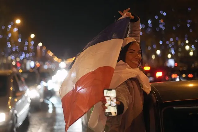 Supporters of France react on the Champs Elysees avenue at the end of the World Cup semifinal soccer match between France and Morocco, in Paris, Wednesday, December 14, 2022. (Photo by Thibault Camus/AP Photo)