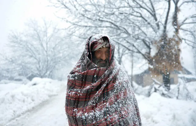 An elderly Kashmiri villager walks through snow in Gund, some 70km northeast from Srinagar, on January 25, 2017. Avalanches killed five people in Indian-administered Kashmir on January 25 – four members of a family whose home was buried under snow and a soldier stationed at a military base. The four family members died when an avalanche ripped through the small village of Badugam in the Gurez area, close to the unofficial border with Pakistan-controlled Kashmir, while they were asleep in their home. (Photo by Tauseef Mustafa/AFP Photo)