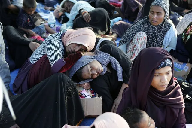 Ethnic Rohingya women rest under a tent after landing on a beach in Kuala Besar, North Sumatra, Indonesia, Sunday, December 31, 2023. Dozens of likely Rohingya refugees, mostly hungry and weak women and children, were found on a beach in Indonesia's North Sumatra province after weeks at sea, officials said on Sunday. (Photo by Dedy Zulkifli/AP Photo)