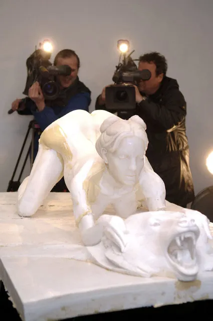 Cameramen film the test mold sculpture of a nude Britney Spears on a bearskin rug while giving birth by artist Daniel Edwards during the Capla Kesting fine arts press conference for Daniel Edwards April 5, 2006 in New York City. The final clay sculpture will be unveiled on April 7 during the gallery opening. (Photo by Bryan Bedder/Getty Images)
