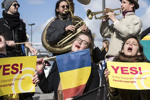 People gather at the front of the European Parliament building in Strasbourg, France, Tuesday March 26, 2019, to show their support for the copyright bill. The European Parliament is furiously debating the pros and cons of a landmark copyright bill one last time before the legislature will vote on it later. (Photo by Jean-Francois Badias/AP Photo)